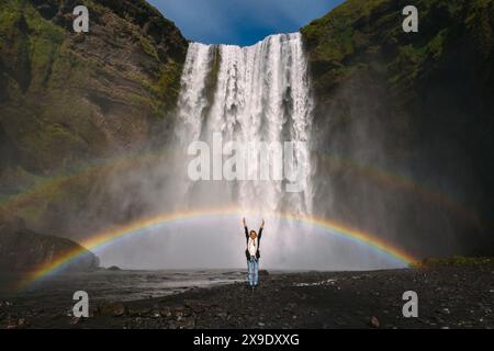 Femme debout devant la cascade Skogarfoss en Islande. Banque D'Images