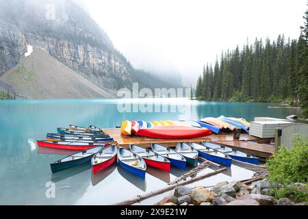 Des canoës colorés entourent un quai au lac Moraine au Canada. Banque D'Images