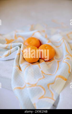 Oranges fraîches sur un tissu à motifs dans un cadre lumineux Banque D'Images