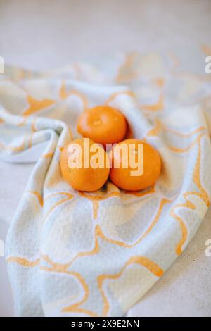 Oranges fraîches sur un tissu à motifs dans un cadre lumineux Banque D'Images