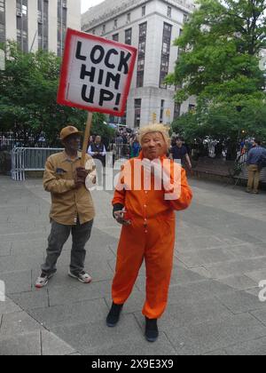 Cour suprême de New York, 100 Centre St, New York, NY 10007 États-Unis. 30 mai 2024. Alors que l’ancien président américain Donald Trump quitte le tribunal suite à sa condamnation pour 34 chefs d’accusation d’ingérence électorale motivée par le « paiement de l’argent caché » lors d’un procès hautement politisé, la plupart du temps des manifestations anti-Trump font rage devant le palais de justice, ponctuées par les rares chapeaux rouges pro-Trump MAGA et les artistes de pantomime cherchant leur journée sous les feux des projecteurs. Crédit : ©Julia Mineeva/EGBN TV News/Alamy Live News Banque D'Images