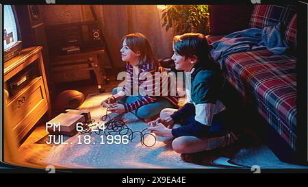 Rétro VHS Tape Effect Home Video concept : jeune frère et sœur jouant Old-School Arcade jeu vidéo sur un téléviseur et console à la maison. Enfants heureux et excités gagnant et souriant. Banque D'Images