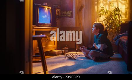 Concept d'enfance nostalgique : jeune garçon jouant à un jeu vidéo d'arcade Old-School sur un téléviseur rétro à la maison dans une chambre avec intérieur correct d'époque. Enfant en attente du niveau à charger. Banque D'Images