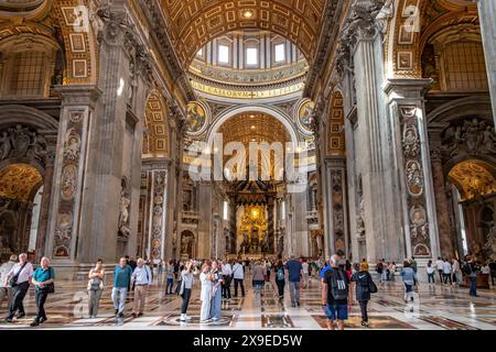 Les gens marchent à travers la nef centrale à l'intérieur de la basilique Saint-Pierre, Cité du Vatican Banque D'Images
