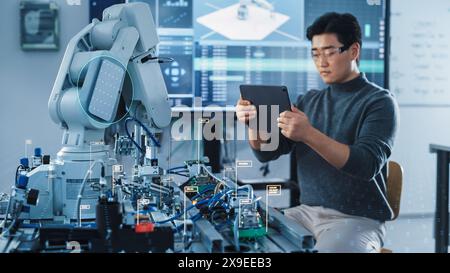 Ingénieur en développement informatique utilisant un ordinateur tablette pour programmer et faire fonctionner un bras de robot. Les icônes de réalité augmentée VFX démontrent le concept innovant de l'industrie 4,0. Banque D'Images