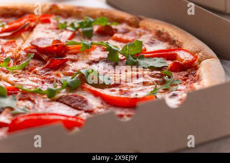 Grande Pizza avec pepperoni et poivrons dans la boîte de carton ouverte vue rapprochée Banque D'Images