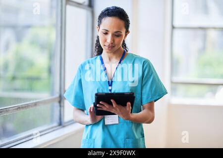 Professionnel de la santé utilisant une tablette numérique en milieu hospitalier Banque D'Images