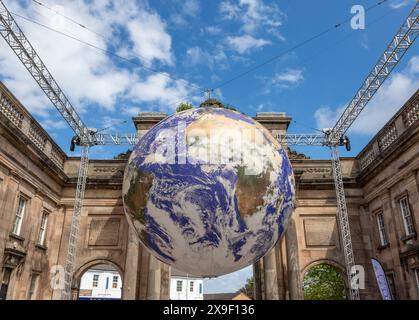 L'œuvre d'art « Gaia » de Luke Jerram exposée à l'entrée principale du parc Birkenhead sur le Wirral dans le cadre des événements de l'arrondissement culturel de Wirral 2024. Banque D'Images