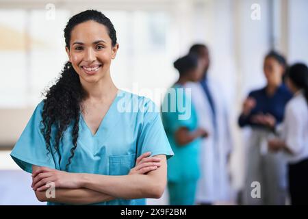 Infirmière femme confiante souriante dans un cadre d'équipe médicale multiethnique Banque D'Images