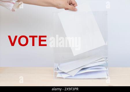 femme électrice de main avec bulletin de vote dans le bureau de vote, droits de vote, , jour de l'élection, devoir civique, participation citoyenne, démocratie Banque D'Images