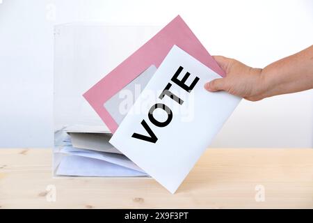 femme électrice de main avec bulletin de vote dans le bureau de vote, droits de vote, , jour de l'élection, devoir civique, participation citoyenne, démocratie Banque D'Images