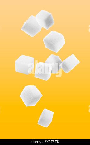 Cubes de sucre raffiné dans l'air sur fond orange Banque D'Images