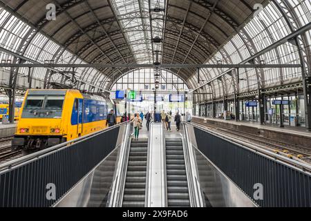 Passagers à côté d'un train dans un quai de la gare centrale d'Amsterdam aux pays-Bas photographié le 29 mai 2024. Banque D'Images