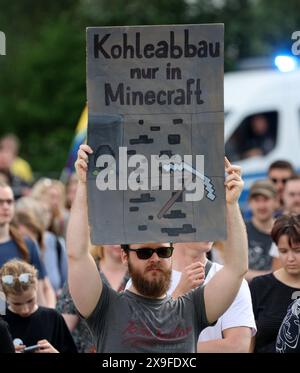 Rostock, Allemagne. 31 mai 2024. Un participant à une manifestation organisée par le mouvement Fridays for future tient une pancarte indiquant «L'extraction de charbon seulement dans Minecraft». La manifestation vise à attirer l'attention sur l'urgence de la crise climatique à l'approche des élections européennes. Les élections européennes auront lieu le 9 juin. Crédit : Bernd Wüstneck/dpa/Alamy Live News Banque D'Images