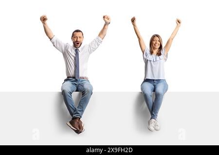 Homme professionnel et une jeune femme assis sur un panneau blanc et levant les bras isolés sur fond blanc Banque D'Images