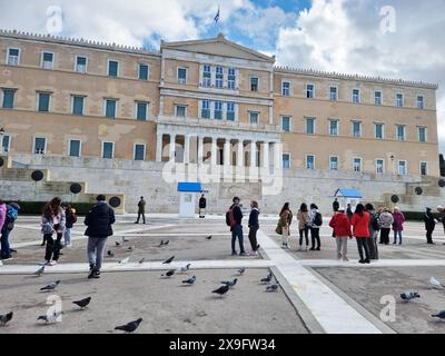 Attraction touristique populaire à Athènes, les cérémonies de la relève de la garde ont lieu au manoir présidentiel et au tombeau du soldat inconnu, qui se trouve sur la place Syntagma, en dessous du Parlement hellénique. Les Evzone, accompagnés d'une bande militaire marchent de leur caserne, juste derrière le bâtiment du Parlement, le long de l'avenue Vasilissis Sofias jusqu'au Tombeau du soldat inconnu où une cérémonie de changement de garde a lieu tous les dimanches à 11:00. Grèce. Banque D'Images