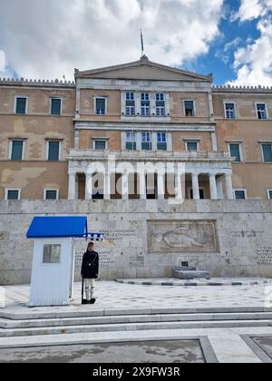 Attraction touristique populaire à Athènes, les cérémonies de la relève de la garde ont lieu au manoir présidentiel et au tombeau du soldat inconnu, qui se trouve sur la place Syntagma, en dessous du Parlement hellénique. Les Evzone, accompagnés d'une bande militaire marchent de leur caserne, juste derrière le bâtiment du Parlement, le long de l'avenue Vasilissis Sofias jusqu'au Tombeau du soldat inconnu où une cérémonie de changement de garde a lieu tous les dimanches à 11:00. Grèce. Banque D'Images