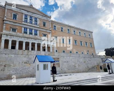 Attraction touristique populaire à Athènes, les cérémonies de la relève de la garde ont lieu au manoir présidentiel et au tombeau du soldat inconnu, qui se trouve sur la place Syntagma, en dessous du Parlement hellénique. Les Evzone, accompagnés d'une bande militaire marchent de leur caserne, juste derrière le bâtiment du Parlement, le long de l'avenue Vasilissis Sofias jusqu'au Tombeau du soldat inconnu où une cérémonie de changement de garde a lieu tous les dimanches à 11:00. Grèce. Banque D'Images