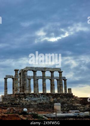 37 km au sud d'Athènes, le temple grec Poséidon se trouve le long de la péninsule Attique. Il est visible par tous les marins qui le traversent et sert de phare pour les Athéniens en mer. Le temple près de l’océan était un endroit approprié pour Poséidon qui est le Dieu de la mer et des tempêtes, et l’un des dieux grecs les plus mauvais, les plus mauvais et les plus gourmands. Le temple a été construit en 444 av. J.-C. et est un endroit populaire pour attraper un coucher de soleil, que vous pouvez regarder à travers ses anciens piliers tandis que le soleil plonge dans la mer Égée. Grèce. Banque D'Images