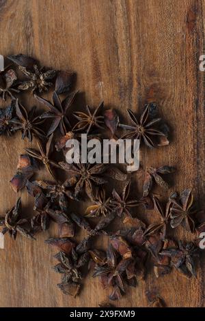 Photographie de nourriture plate d'étoiles d'anis sur une planche à découper d'acacia, épices aromatiques sur fond de bois Banque D'Images