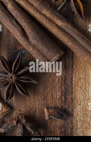 Photographie alimentaire en gros plan à plat de bâtons de cannelle et d'étoiles d'anis sur une planche à découper en acacia, épices aromatiques sur fond de bois Banque D'Images