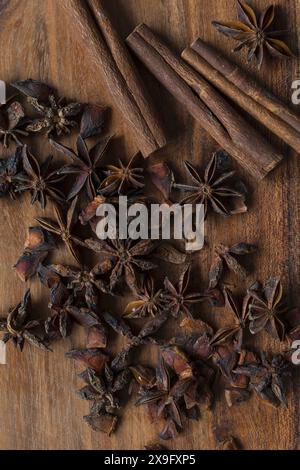 Photographie de nourriture plate de bâtons de cannelle et d'étoiles d'anis sur une planche à découper d'acacia, épices aromatiques sur fond de bois Banque D'Images