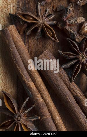 Photographie alimentaire en gros plan à plat de bâtons de cannelle et d'étoiles d'anis sur une planche à découper en acacia, épices aromatiques sur fond de bois Banque D'Images