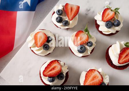 Gourmandises et bouchées de velours rouge avec crème fouettée et fraise. Des collations saines du 4 juillet pour les enfants. Article facile à servir à la fête patriotique fo Banque D'Images