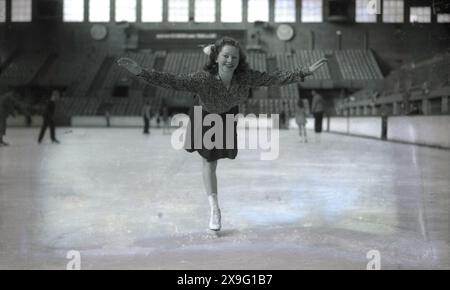 1939, Cecilia Colledge, championne européenne de patinage artistique en titre, sur la glace en pratique à l'Empress Hall, Earls court, Londres, Angleterre, Royaume-Uni. La salle était le lieu de l'épreuve féminine des Championnats d'Europe de patinage artistique 1939, remportés par Colledge sur une autre patineuse britannique, Megan Taylor. Construit à l'origine à la fin des années 1880, comme théâtre, il a été utilisé pendant la première Guerre mondiale pour héberger des réfugiés, puis comme dépôt de stockage. En 1935, il a été converti en anneau de patinage sur glace et est devenu la maison des spectacles musicaux sur glace de Londres. La salle a fermé en 1958. Banque D'Images