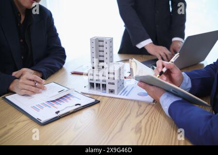 groupe d'hommes d'affaires et d'investisseurs discuter d'investir dans l'immobilier et planifier conjointement des investissements dans des projets de construction de condominiums et appartements Banque D'Images