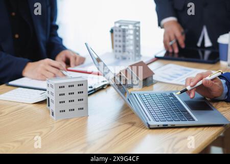 groupe d'hommes d'affaires et d'investisseurs discuter d'investir dans l'immobilier et planifier conjointement des investissements dans des projets de construction de condominiums et appartements Banque D'Images