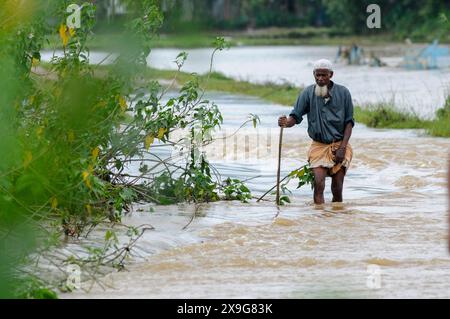 Sylhet, Bangladesh. 30 mai 2024. Les personnes âgées luttent pour patauger sur la route principale inondée de Lafnaut, dans la région de Goanghat upazila, en raison des fortes pluies après que le cyclone Remal a frappé le Bangladesh. Le 30 mai 2024 à Sylhet, Bangladesh. (Photo de MD Rafayat Haque Khan/ Eyepix Group/Sipa USA) crédit : Sipa USA/Alamy Live News Banque D'Images