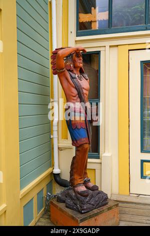 Statue d'un chef indigène dans le vieux centre-ville de Skagway, Alaska - homme aborigène portant une couronne à plumes dans le Histo national de la ruée vers l'or du Klondike Banque D'Images