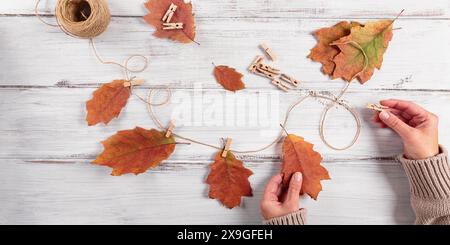 Guirlande maison de feuilles d'automne colorées avec des mains de femmes Banque D'Images