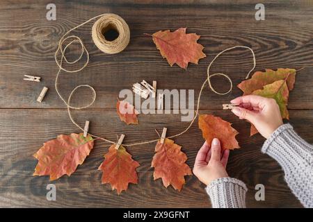 Guirlande maison de feuilles d'automne colorées avec des mains de femmes Banque D'Images
