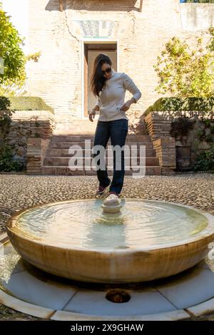 Jeune femme en lunettes de soleil aux jardins du Generalife à Grenade, Andalousie, Espagne, partie de l'Alhambra Banque D'Images