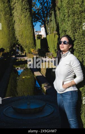 Jeune femme en lunettes de soleil aux jardins du Generalife à Grenade, Andalousie, Espagne, partie de l'Alhambra Banque D'Images