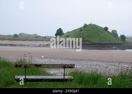 Banc surplombant l'estuaire et Church Hill avec St Cuthberts Cross lors d'une journée sombre à Alnmouth Northumberland UK Banque D'Images