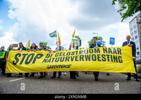 Amsterdam, pays-Bas. 31 mai 2024. Les manifestants tiennent une banderole pendant la manifestation. Des milliers de personnes se sont rassemblées au centre du cœur financier des pays-Bas, à Amsterdam, pour arrêter des milliards de subventions aux pollueurs fossiles. Plusieurs organisations climatologiques veulent exiger une politique (climatique) équitable, juste avant les élections européennes. Crédit : SOPA images Limited/Alamy Live News Banque D'Images