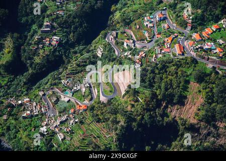 Vue aérienne de la route en épingle à cheveux menant au village de Curral das Freiras vu du point de vue Eira do Serrado dans le cadre montagneux de la Banque D'Images