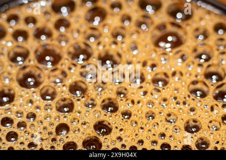 bulles de mousse texturées avec effet bokeh sur la surface de la tasse à café chaude Banque D'Images