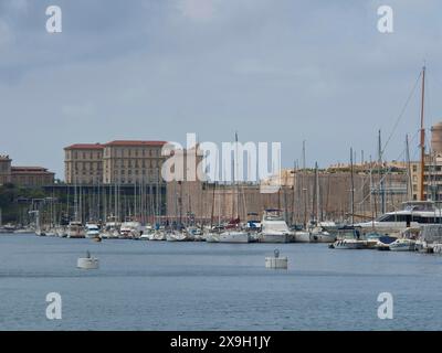 Un port plein de bateaux et de yachts avec des bâtiments historiques et des mâts à voile en arrière-plan, Marseille sur la mer Méditerranée avec l'ancien Banque D'Images