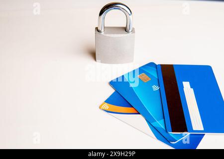 Concept de contrôle des dépenses, un cadenas fermé et une clé à côté des cartes de crédit, en arrière-plan un clavier d'ordinateur, sur un fond blanc. Banque D'Images