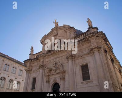 Église baroque avec des sculptures ornées et de magnifiques détails architecturaux contre un ciel bleu clair, la vieille ville de Dubrovnik avec des maisons historiques Banque D'Images