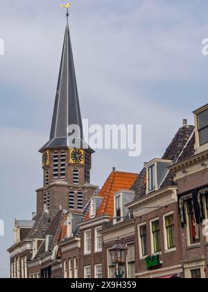 Tour d'église avec horloge et bâtiments historiques environnants sous un ciel bleu, maisons historiques à Hoorn et navires dans le port, hoorn, pays-bas Banque D'Images