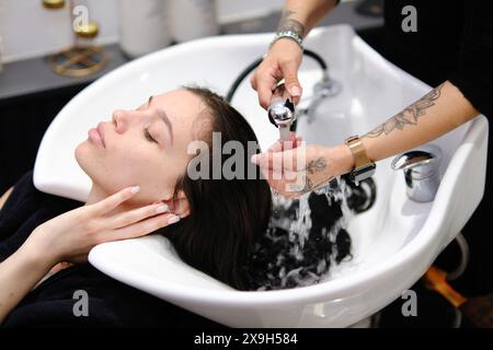 Tirana, Albanie - 17 mai 2024 : coiffeuse travaillant dans un salon. Banque D'Images