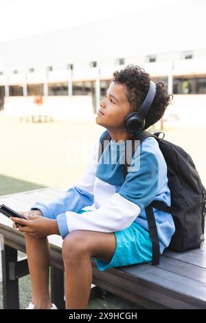 Biracial Boy aime la musique à l'extérieur à l'école, avec un espace de copie Banque D'Images