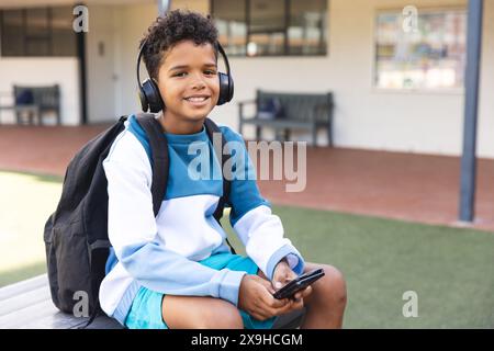 Biracial Boy aime la musique à l'école, avec un espace de copie Banque D'Images