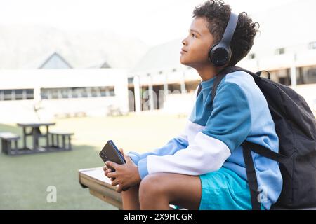 Biracial Boy aime la musique à l'école, avec un espace de copie Banque D'Images