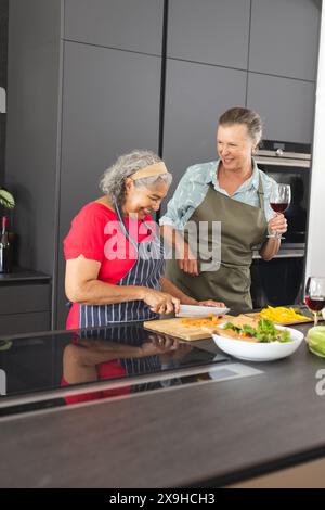 Diverses amies seniors cuisinant ensemble à la maison Banque D'Images